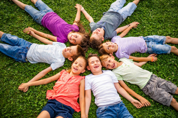 istock View above group of kids lying down on grass in circle 1006649546