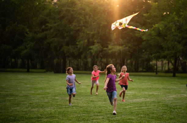 istock Group of children running with kiteflying 1006658310