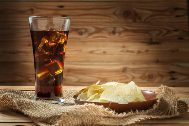 istock Potato chips with cola on a wooden background 1006658796