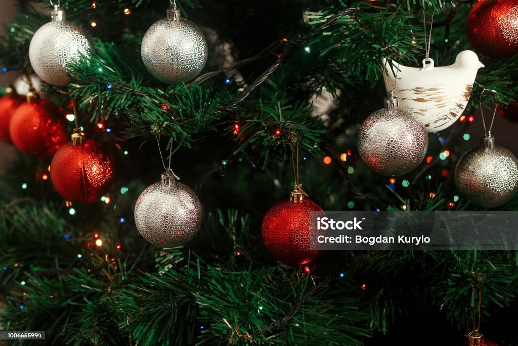 Foto de Enfeites De Natal Prata E Vermelho Pendurado Em Uma Árvore De Natal  Verde Com Luzes Azuis Foco Em Bonito Branco Pomba Decoração De Pássaro e  mais fotos de stock de