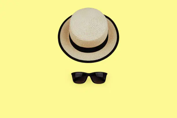 sunprotection objects sunglasses and hat on yellow background. Lay flat. Top view.