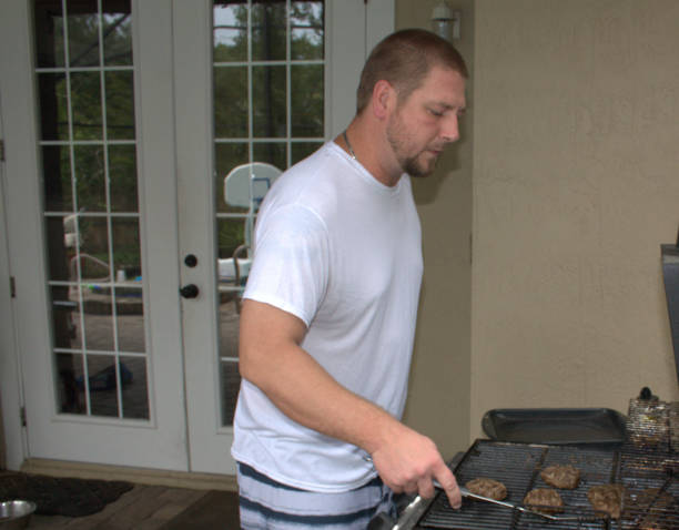 istock Man grilling burgers on patio 1006668890