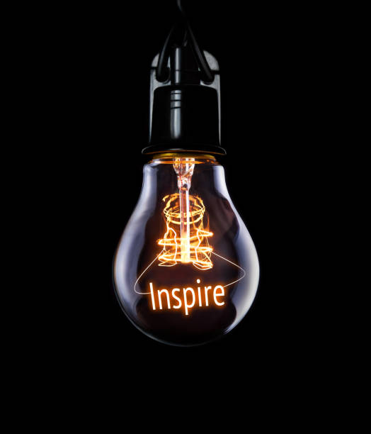 suspension ampoule rougeoyante inspire concept. - business environment responsibility light bulb photos et images de collection