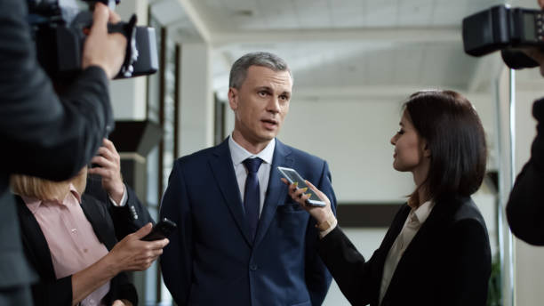 Politic man giving interview willingly Adult formal man of government deputy talking to group of journalists and giving interview with smile looking excited with success politician stock pictures, royalty-free photos & images