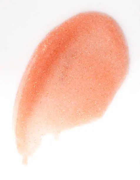 apricot lipgloss smudge over white background