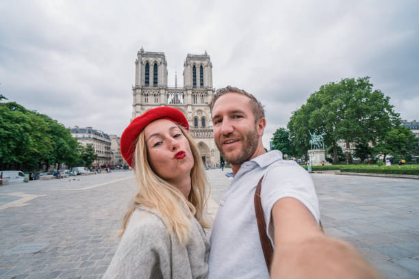 ritratto selfie di giovane coppia nella cattedrale di notre dame de paris a parigi, francia; girato al mattino, persone di viaggio scoperta concetto città - paris france heterosexual couple couple french culture foto e immagini stock