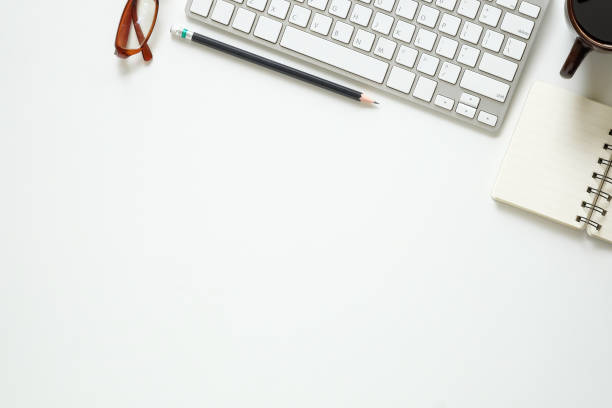 istock Top view office desk with computer, pencil, glasses, notebook paper and coffee cup. 1006687586