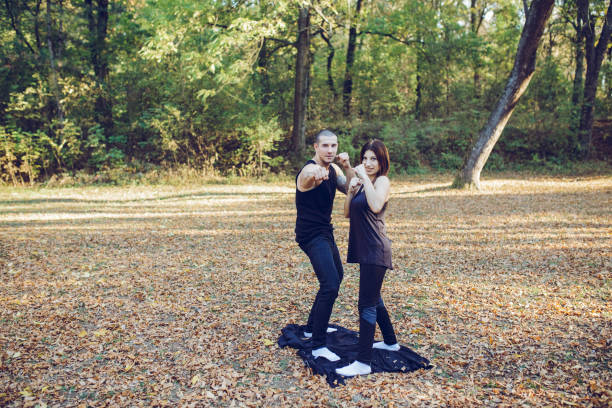 istock Athletic couple posing with raised fists in nature 1006687672
