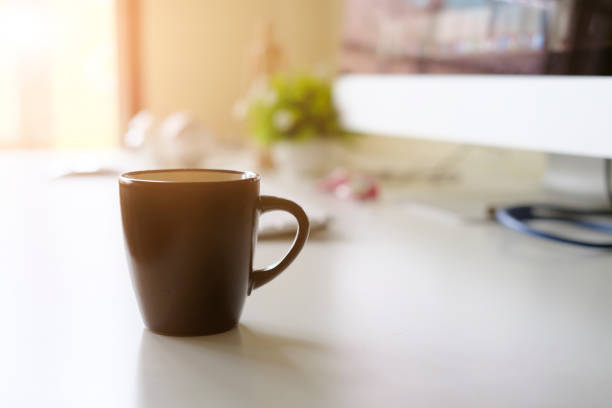 istock Mug of coffee on office workplace with morning coffee concept. 1006688180