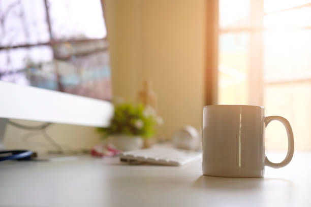 istock Mug of coffee on office workplace with morning coffee concept. 1006688352