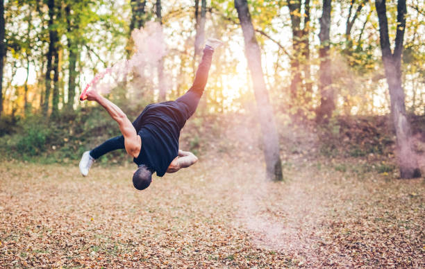 istock Male acrobatics with smoke fountain in forest 1006688418