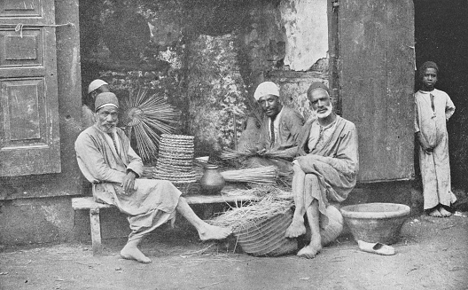 Group of men making baskets for sale in Cairo, Egypt. Vintage halftone photo etching circa late 19th century.