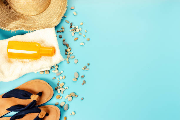 istock Top view of flip flops, straw hat and white towel 1006692576