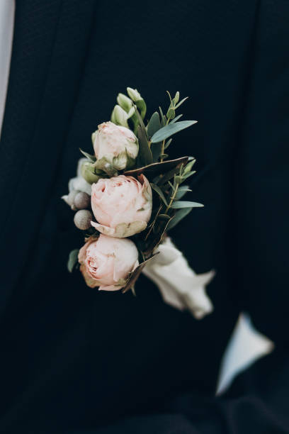 세련 된 신랑에 장미와 럭셔리 boutonniere 맞게. 텍스트를 위한 공간입니다. 써니 결혼식 날입니다. 핑크 꽃과 턱시도 가슴에 녹색 잎입니다. 현대 봐, 근접 - necktie pink shirt luxury 뉴스 사진 이미지