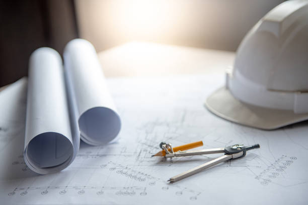 ferramenta de bússola e a segurança do capacete em plano de desenho arquitetônico do projeto da casa, planta rola na mesa de trabalho, arquitetura e construção civil, conceitos de indústria - paper rolls - fotografias e filmes do acervo