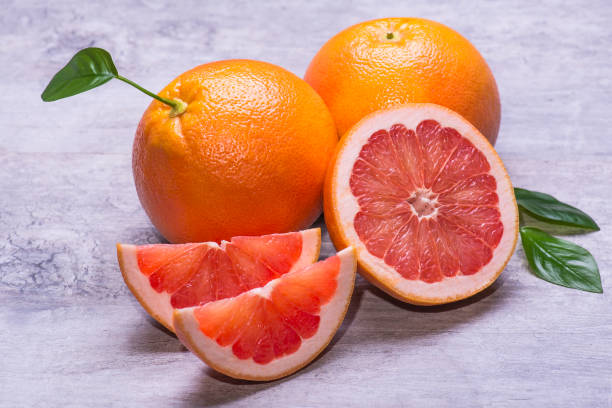 istock Grapefruit whole, half and pieces ripe, juicy on a gray background 1006697588