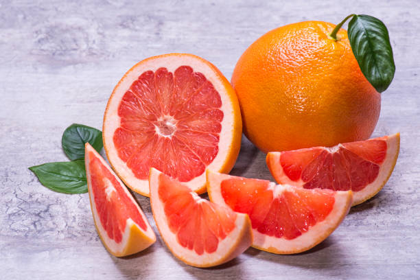 istock Grapefruit whole, half and pieces ripe, juicy on a gray background 1006697664