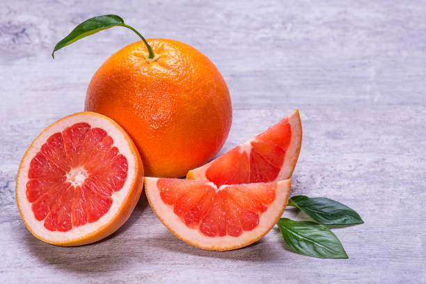 istock Grapefruit whole, half and pieces ripe, juicy on a gray background 1006698102