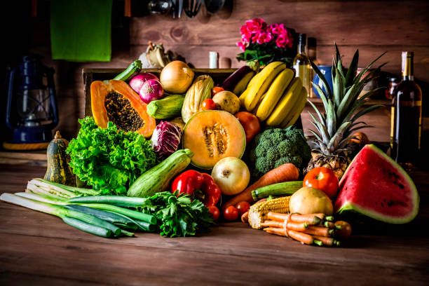 Cutting board in a rustic kitchen ready to cut and process organic tropical fruits and vegetables. Natural lighting