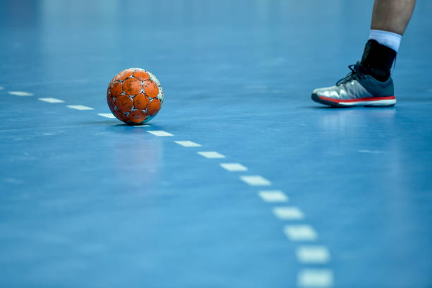 ballon de handball portant sur la ligne pointillée de 9 mètres - faute de main photos et images de collection