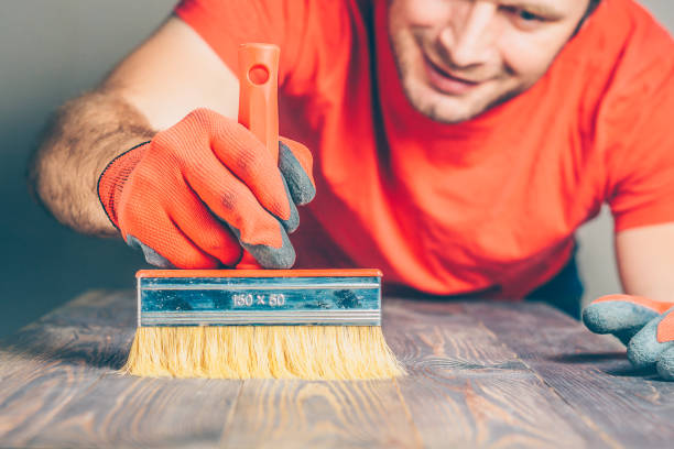 maestro aplica pincel de aceite en una junta de muebles de madera - wood deck wood stain paint fotografías e imágenes de stock