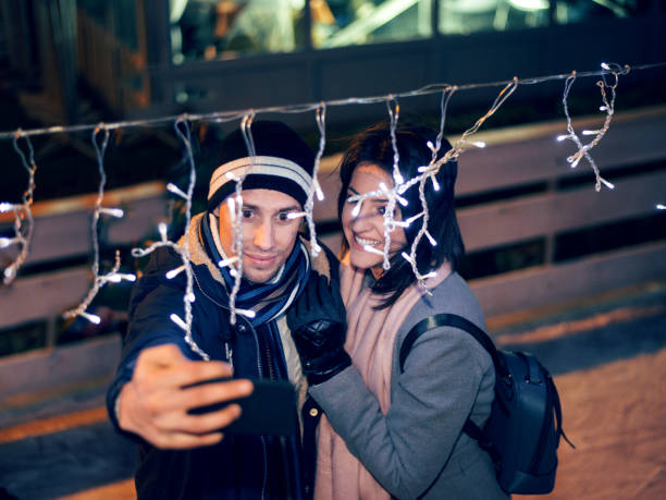 istock Young romantic couple taking Selfie while ice-skating 1006724396