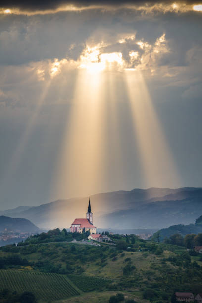 sonnenstrahlen leuchtendes nach unten auf eine kirche. - gods rays stock-fotos und bilder