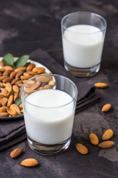 istock Almond milk in glass and almonds nuts on a dark background 1006753918