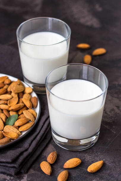 istock Almond milk in glass and almonds nuts on a dark background 1006753944