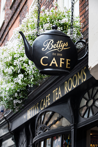 York, UK - July 18, 2018.  The exterior and facade of the popular tourist attraction The Little Betty's Cafe and Tea Rooms showing the large tea pot sign in York, UK
