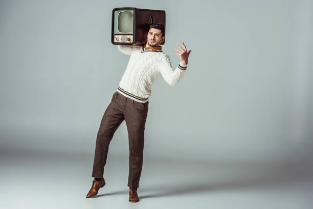istock retro styled handsome man posing with vintage television on shoulder 1006767342