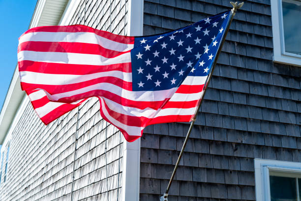 Old building in Maine weather by the sun with American flag flying proudly.