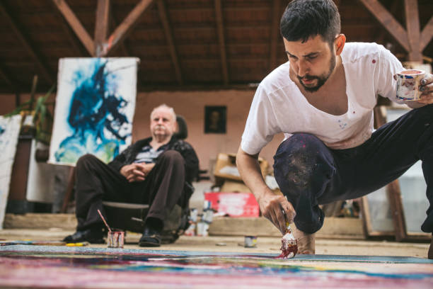 istock Senior man resting while his son is painting 1006775596
