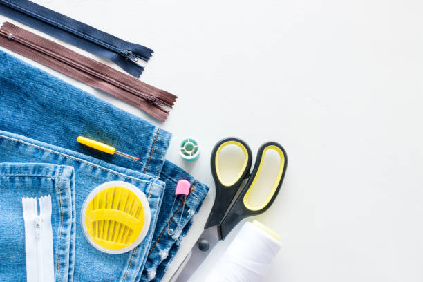 Denim and sewing accessories on white background with place for text