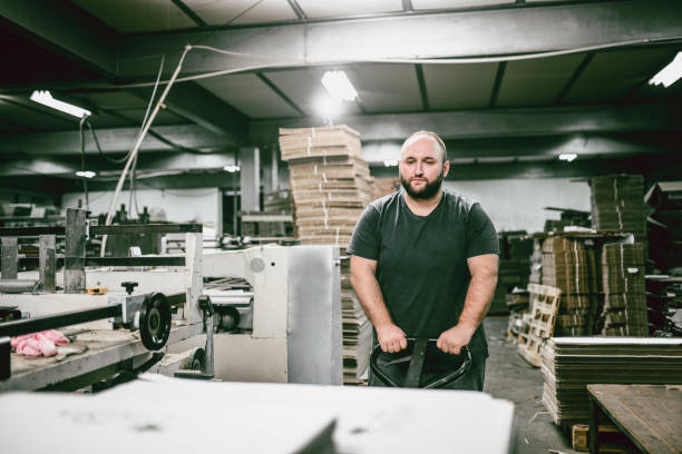 istock Cardboard Factory Worker Pushing Cart With Merchandise 1006810188
