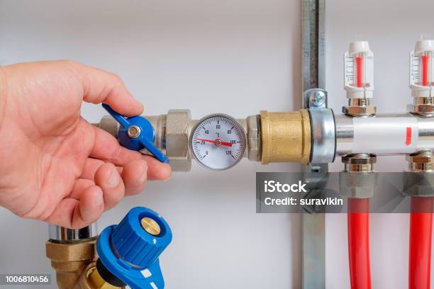 The Mens Hand Opens The Ball Valve On The Collector Stock Photo - Download Image Now