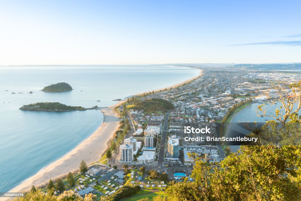 Mount Maunganui stretches out below as sun rises on horizon and falls across ocean beach and buildings Mount Maunganui stretches south out below as sun rises on horizon and falls across ocean beach and buildings below Tauranga Stock Photo