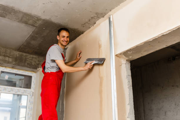 istock A worker with spatula in workwear makes repairs the wall 1006839558