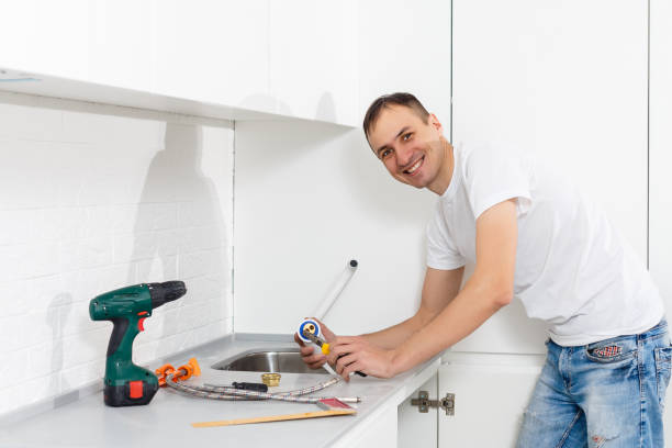 istock Handsome man holding a drill repairing a kitchen sink at home 1006853064