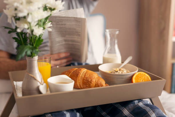istock Man reading newspapers and having breakfast in bed 1006853914
