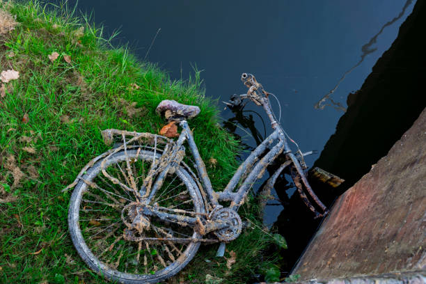 istock rusty old bicycle lying abandoned on field, along water in Alkmaar, The Netherlands 1006864760