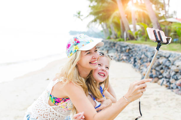 istock Cheerful Mother And Daughter Taking Selfie At Beach 1006865520