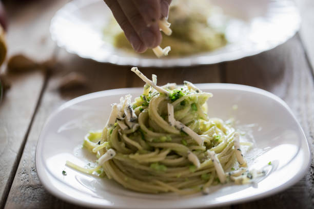 Simple pasta dish - spaghetti with avocado pesto, mold cheese, and dry fried sesame seed. Close up, no people
