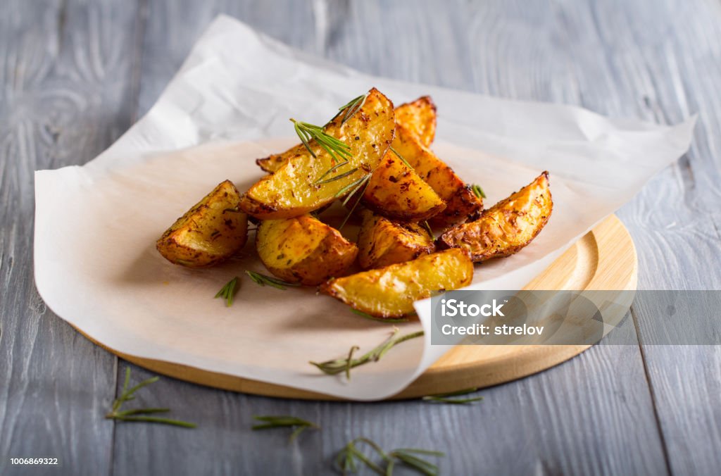 grilled potatoes rosemary wooden background Prepared Potato Stock Photo