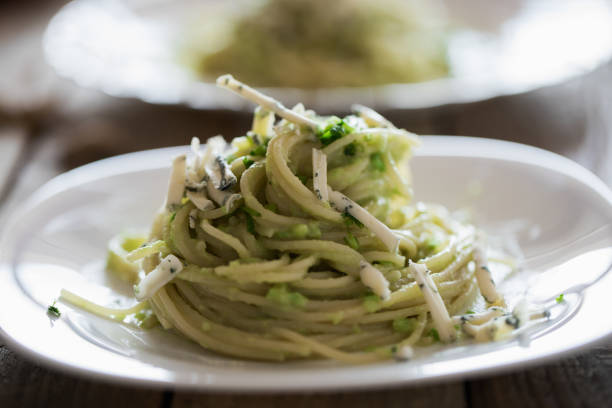 Simple pasta dish - spaghetti with avocado pesto, mold cheese, and dry fried sesame seed. Close up, no people