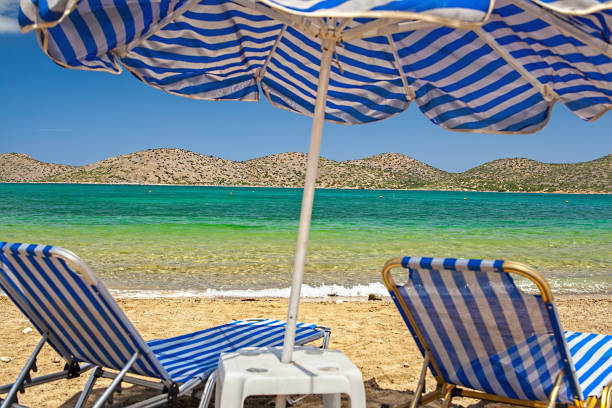 istock Sunbeds and beach umbrella by the sea 1006875362