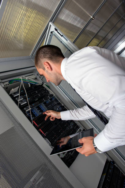 istock Young handsome business man engeneer in datacenter server room 1006875594