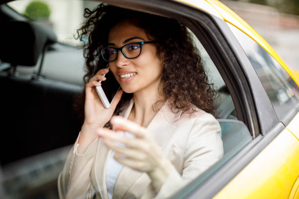 istock Businesswoman using smart phone while commuting to work by taxi 1006875742