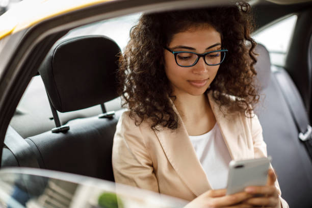 istock Businesswoman using smart phone in a car 1006875752