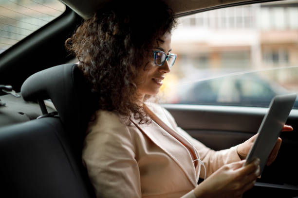 車でデジタル タブレットを使用して若い実業家 - digital tablet businesswoman young women watching ストックフォトと画像